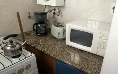 a kitchen counter with a microwave and a stove at Cabañas Cerro Cristal in La Cumbrecita
