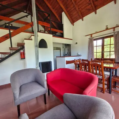 a living room with a red couch and chairs at Cabañas Cerro Cristal in La Cumbrecita