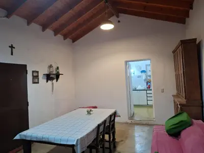 a room with a table and a cross on the wall at Rancho La Paz in Los Reartes