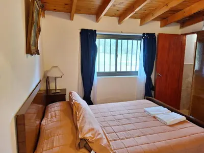 a bedroom with a bed and a window at Rancho La Paz in Los Reartes