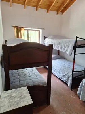 a bedroom with two bunk beds and a window at Rancho La Paz in Los Reartes
