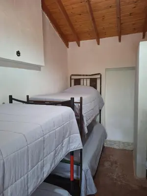 two bunk beds in a room with a wooden ceiling at Rancho La Paz in Los Reartes