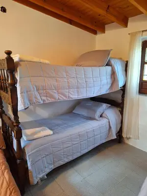 a bedroom with a bunk bed with blue sheets at Rancho La Paz in Los Reartes