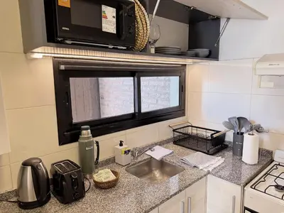 a small kitchen with a sink and a microwave at Apartamento Obispo Trejo, Nueva Cordoba in Cordoba