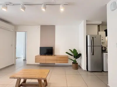 a living room with a table and a refrigerator at Apartamento Obispo Trejo, Nueva Cordoba in Cordoba