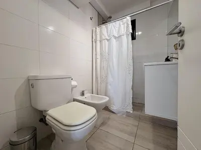 a white bathroom with a toilet and a shower at Apartamento Obispo Trejo, Nueva Cordoba in Cordoba