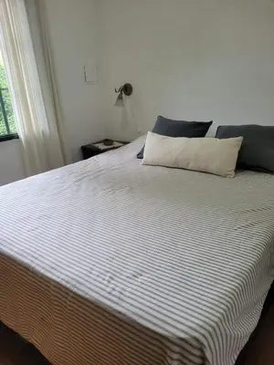 a bed with a white and blue striped blanket at 