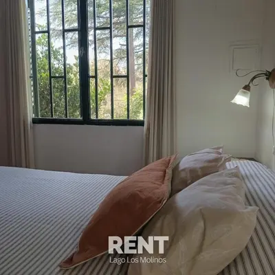 a bedroom with a bed with pillows and a window at 