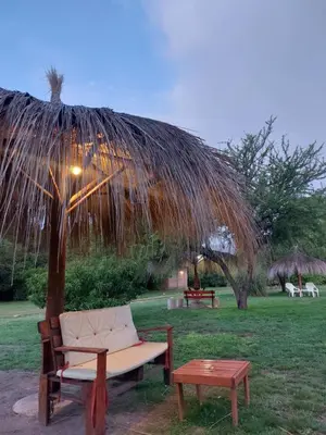 a chair and a table under a straw umbrella at Pasión Serrana in Las Calles