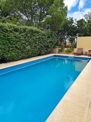 a swimming pool with blue water in a yard at INCA HUASI - Cabañas de Altura in El Rincón