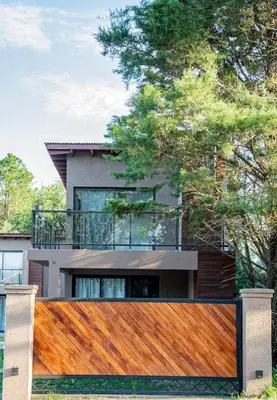 a wooden fence in front of a house at Complejo Montana Departamento 3 in Potrero de Garay