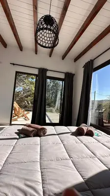 a large bed in a room with large windows at Complejo Montana Departamento 3 in Potrero de Garay