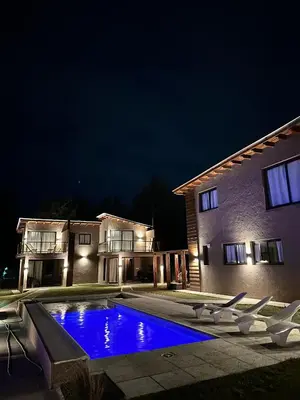 a house with a swimming pool at night at Complejo Montana Departamento 3 in Potrero de Garay