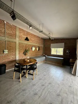 a room with a table and chairs and a brick wall at Cabañas Cuesta in Cordoba
