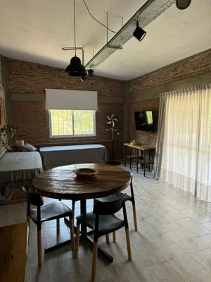 a living room with a wooden table and chairs at Cabañas Cuesta in Cordoba