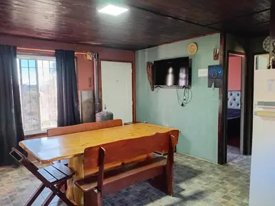 a dining room with a wooden table and chairs at La Lugarda in Cuesta Blanca