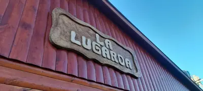 a sign on the side of a red building at La Lugarda in Cuesta Blanca