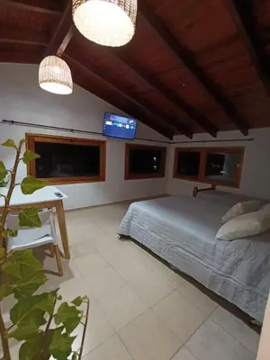 a bedroom with a bed and a desk and windows at Potrero Loft in Potrero de Garay