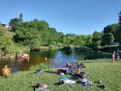 a group of people laying on the grass near a river at Potrero Loft in Potrero de Garay