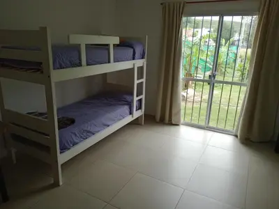 a room with two bunk beds and a sliding glass door at Dúplex, Alejandría in Villa Carlos Paz