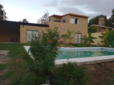 a house with a swimming pool in front of a house at Dúplex, Alejandría in Villa Carlos Paz