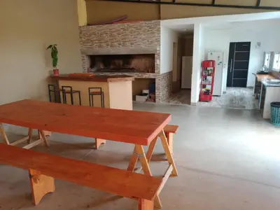 a table and benches in a room with a fireplace at Dúplex, Alejandría in Villa Carlos Paz