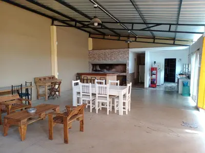 a room with wooden tables and chairs and a brick wall at Dúplex, Alejandría in Villa Carlos Paz