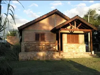 a small wooden house with a stone facade at Cabañas Raices in Mina Clavero