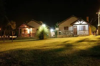 a house at night with lights in a yard at Cabañas Raices in Mina Clavero