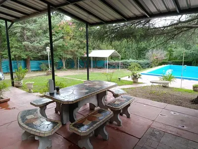 a picnic table and benches on a patio at Villa Clara in Villa Parque Siquiman