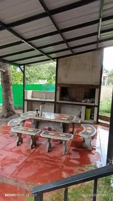 a picnic table and benches under a shelter at Villa Clara in Villa Parque Siquiman