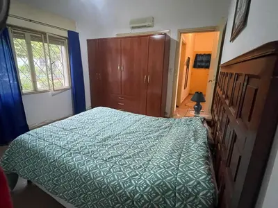 a bedroom with a bed with a green comforter at Villa Clara in Villa Parque Siquiman