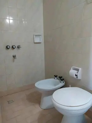 a bathroom with a white toilet and a sink at Valle Hermoso in Mina Clavero