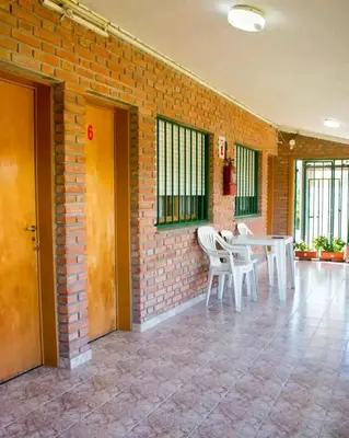 a room with a brick wall and a table and chairs at Valle Hermoso in Mina Clavero