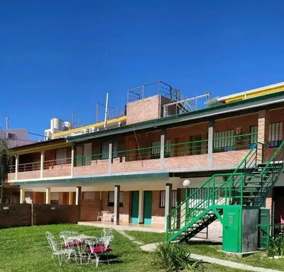 a building with a green staircase and tables and chairs at Valle Hermoso in Mina Clavero