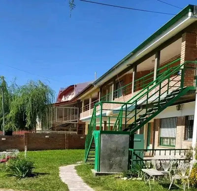 a building with a green staircase in front of it at Valle Hermoso in Mina Clavero