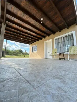 a large patio with a table and chairs in a building at Casa WIWI in La Estancia