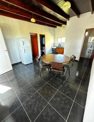a dining room with a table and a refrigerator at Casa WIWI in La Estancia