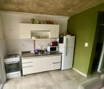 a small kitchen with white appliances and green walls at Magdalena in Santa Rosa de Calamuchita