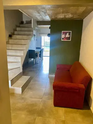 a living room with a couch and a staircase at Magdalena in Santa Rosa de Calamuchita