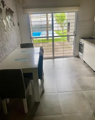 a kitchen with a table and chairs and a window at Magdalena in Santa Rosa de Calamuchita
