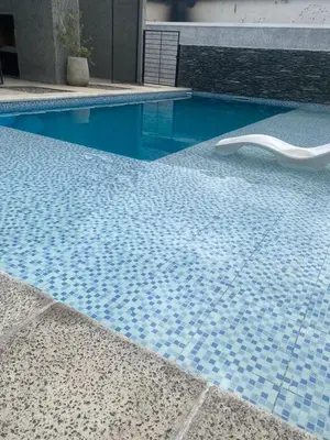 a blue tile swimming pool with a white chair in it at Magdalena in Santa Rosa de Calamuchita
