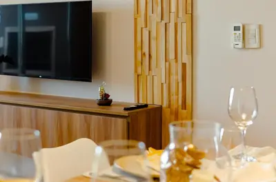 a dining table with wine glasses and a flat screen tv at TempoHome in Cordoba