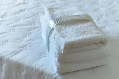 a stack of towels sitting on top of a bed at TempoHome in Cordoba