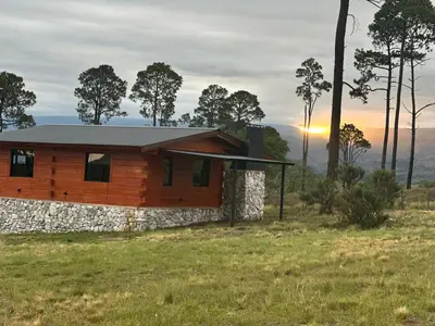 a house on a hill with the sunset in the background at La Eugelina in Santa Rosa de Calamuchita
