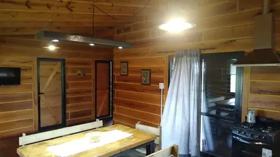a dining room with wooden walls and a wooden table at La Eugelina in Santa Rosa de Calamuchita