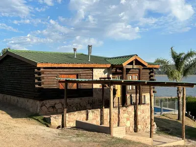 a small log cabin with a green roof at Cabaña Ari in Villa Santa Cruz del Lago