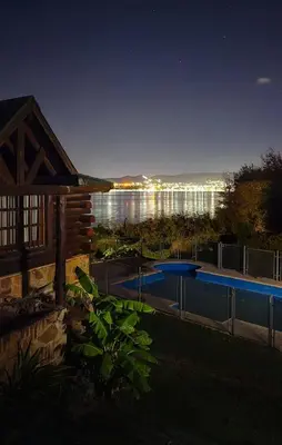 a house with a swimming pool at night at Cabaña Ari in Villa Santa Cruz del Lago