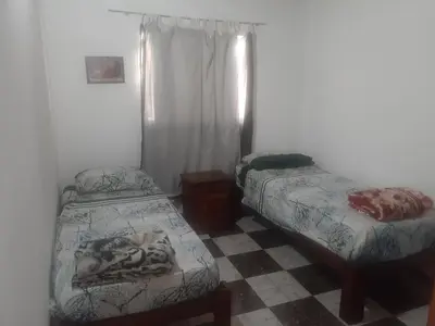 a bedroom with two beds and a checkered floor at Posada clara in Cordoba