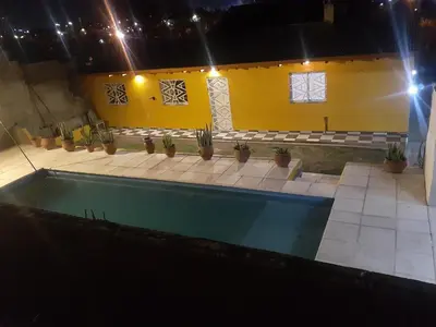 a swimming pool in a room with potted plants at Posada clara in Cordoba